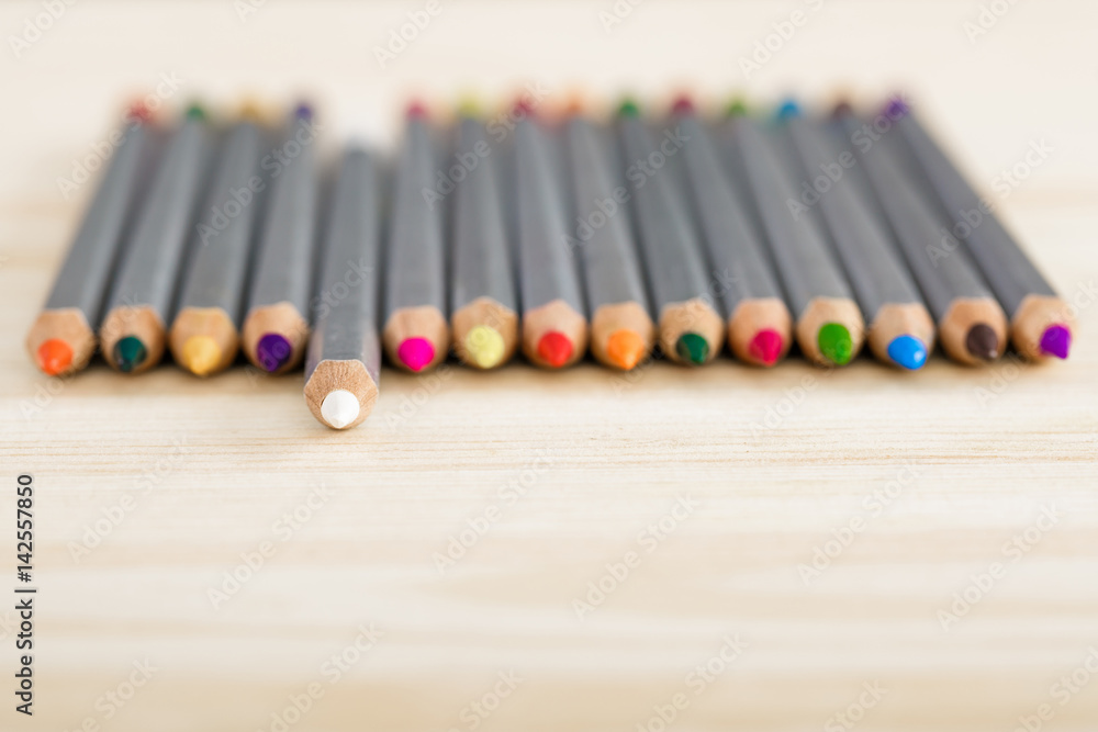 Naklejka premium set of different colored pencils on wooden desk