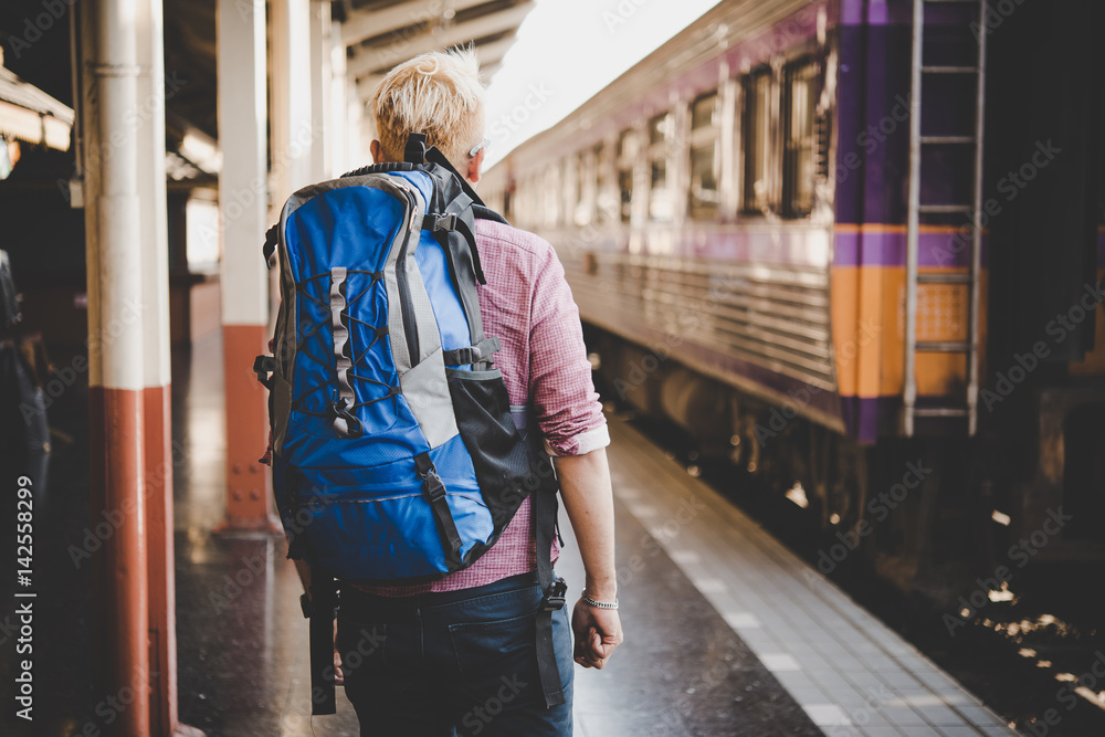 Young hipster tourist with backpack on the train station. Holiday tourist concept. Young hipster tourist with backpack on the train station. Holiday tourist concept.