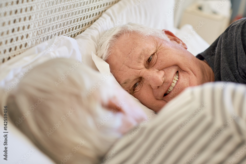 Smiling senior couple looking at each other in bed Smiling senior couple looking at each other in bed