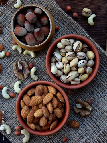 A composition from different varieties of nuts on a wooden background - almonds, cashews, peanuts, walnuts, hazelnuts, pistachios.