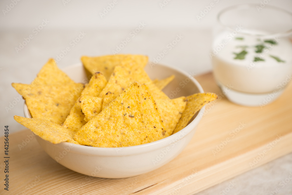 Delicious nachos with cheese on the white wooden background. Shallow depth of field. Delicious nachos with cheese on the white wooden background. Shallow depth of field.