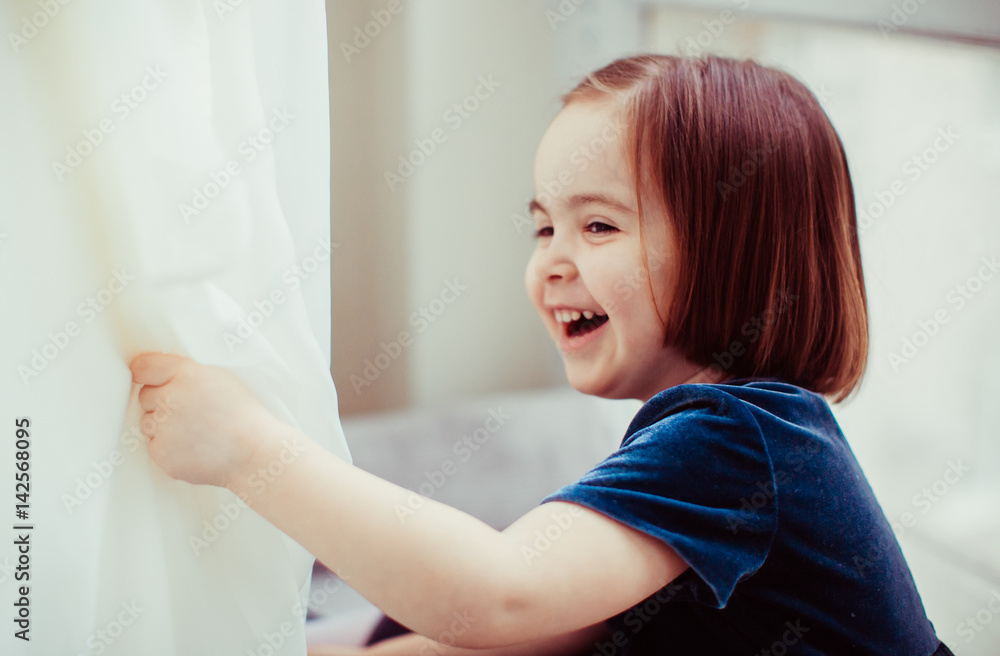 Fototapeta premium The pretty girl sits on the window-sill