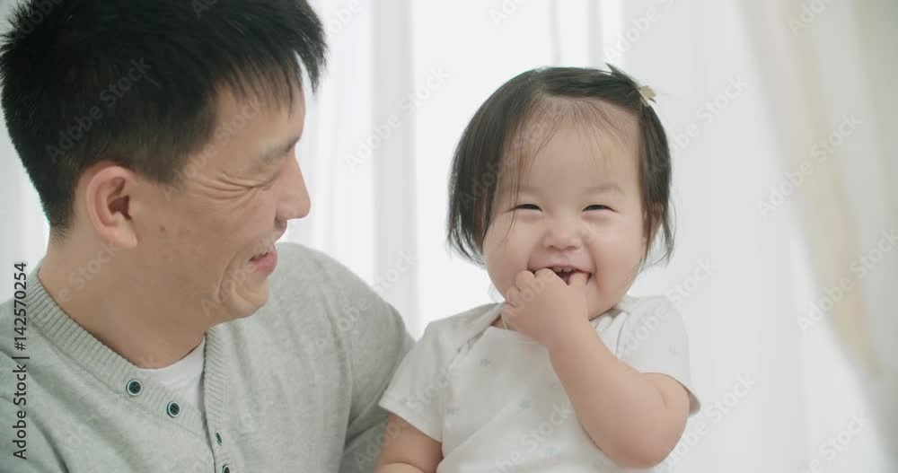 slow motion, little cheerful Asian girl playing with her parents ,moments of happiness in the family slow motion, little cheerful Asian girl playing with her parents ,moments of happiness in the family