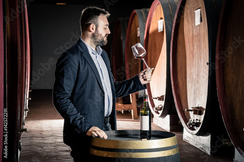Fotografie Sommelier tasting red wine in the cellar