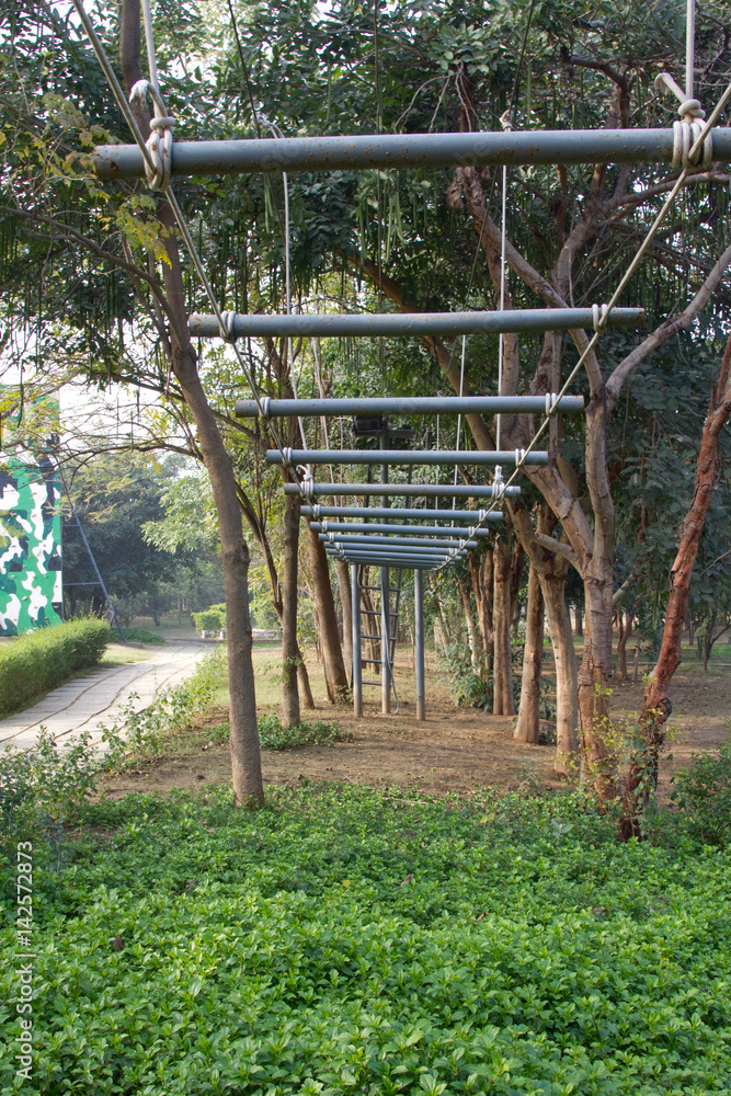 Small rope bridge for recreational use at a resort on the outskirts of Gurgaon, Haryana (India). Vertical shot. Small rope bridge for recreational use at a resort on the outskirts of Gurgaon, Haryana (India). Vertical shot.