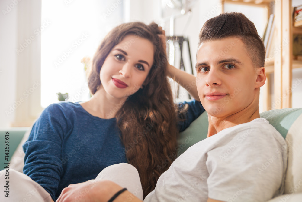 Couple on sofa looking at camera home interior Couple on sofa looking at camera home interior