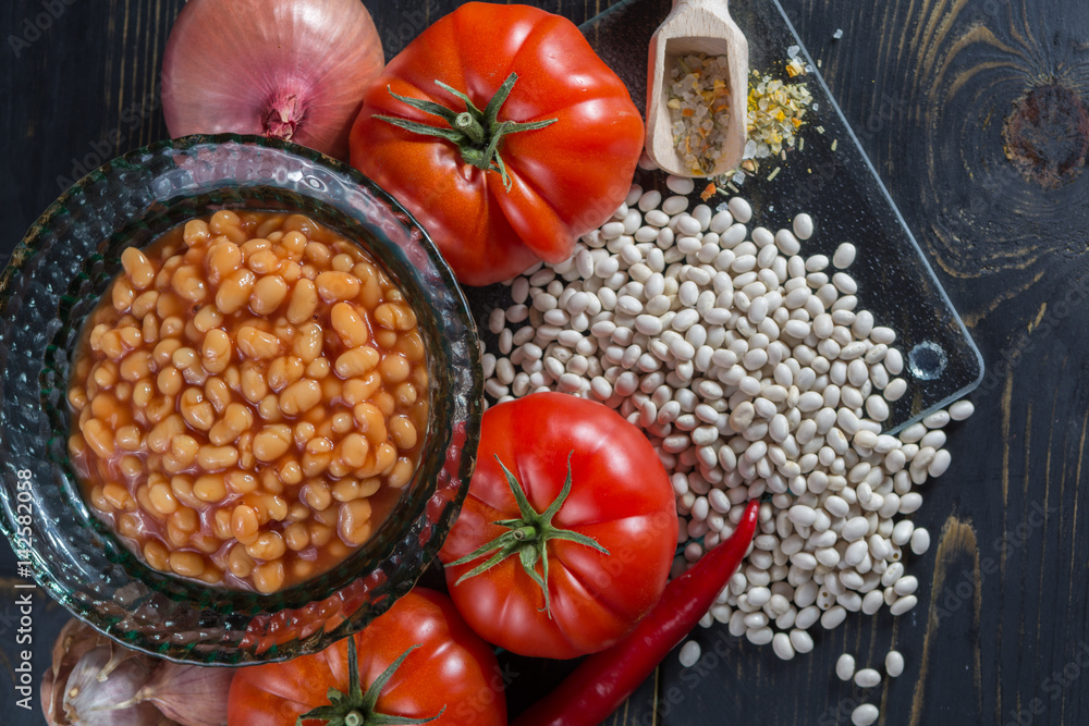 Traditional English food - baked white beans in tomato sauce and ingredients ready to cook Traditional English food - baked white beans in tomato sauce and ingredients ready to cook