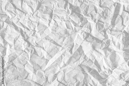 Surface of crumpled paper highlighted by light. Stressed, illuminated sheet of paper paper.