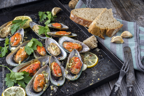 Backed Green Shell Mussels on old rustic sheet with Bread