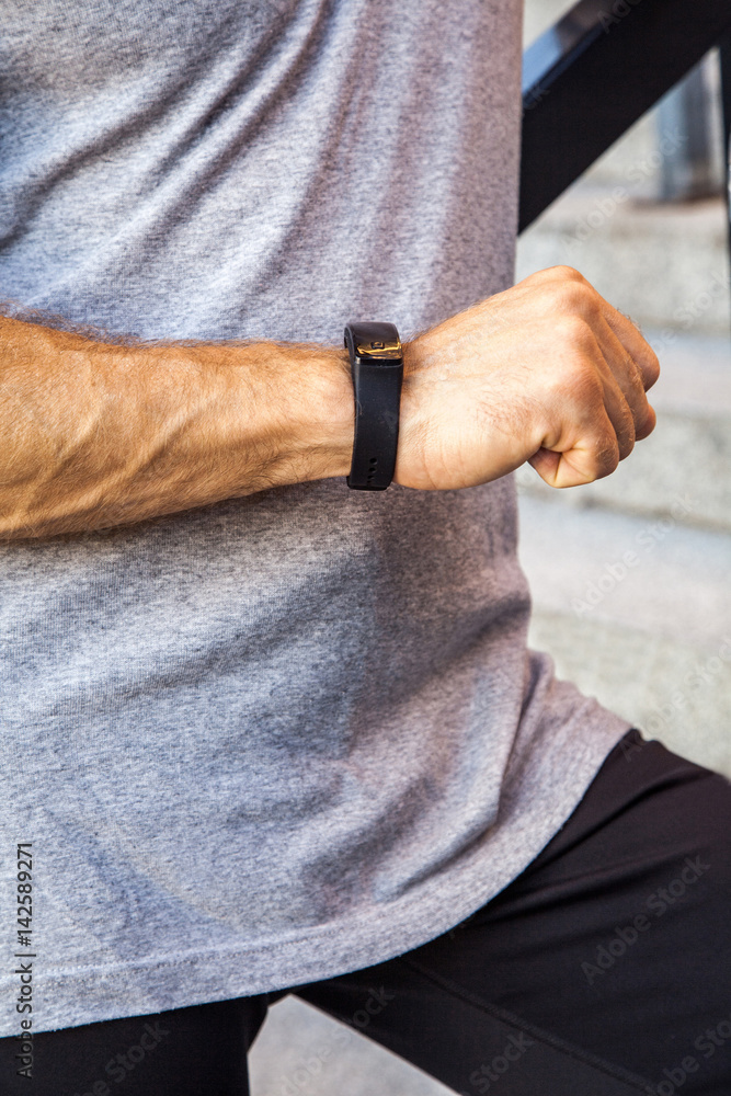 Sportsman with bottle of water is resting and checking his smart watch after running. fitness, sport, exercising and people healthy lifestyle concept.