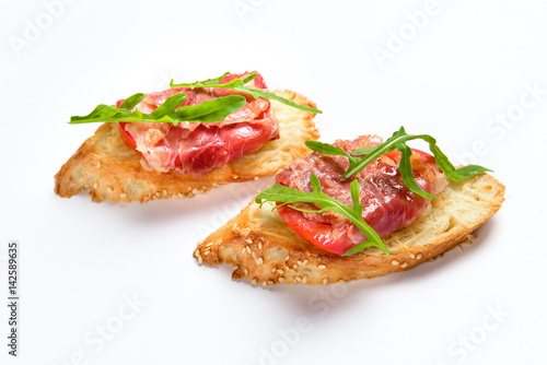 Two sandwiches with serrano ham, cheese and arugula photo
