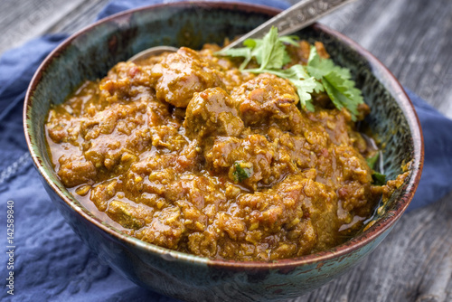 Traditional Indian Lamb Curry as close-up in a bowl photo