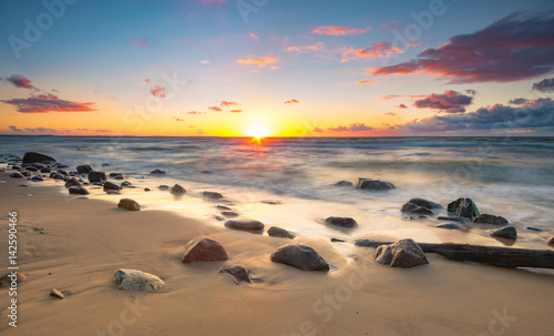 Colorful sunset over a sea beach during a storm