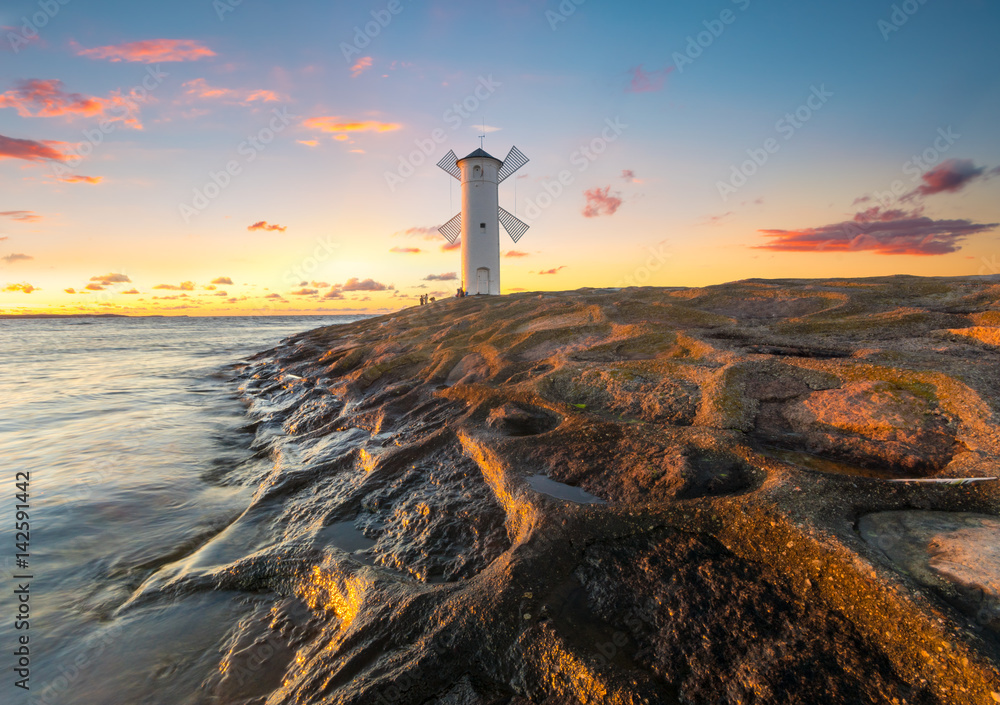 Beautiful sunset over a windmill-shaped lighthouse, Swinoujscie, Poland. - obrazy, fototapety, plakaty 