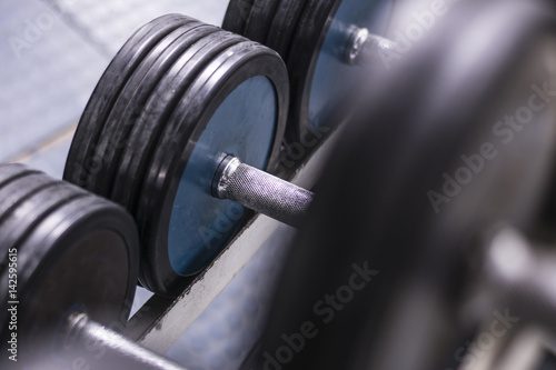 Close up. Old school gym interior with equipment, bodybuilding background. Heavy iron dumbbells stacked in rows.