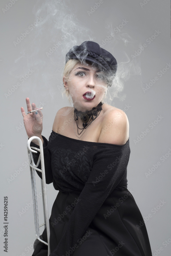 Girl with a cigarette on a gray background Girl with a cigarette on a gray background