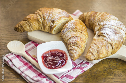 Croissants breakfast composition on kitchen table. photo