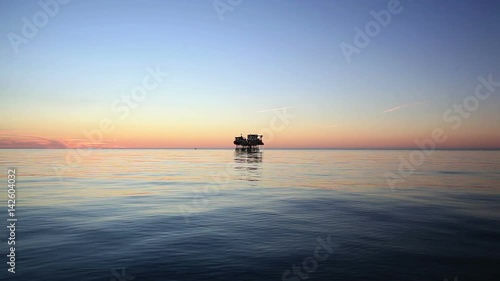 Silhouette of offshore oil platform at sunset