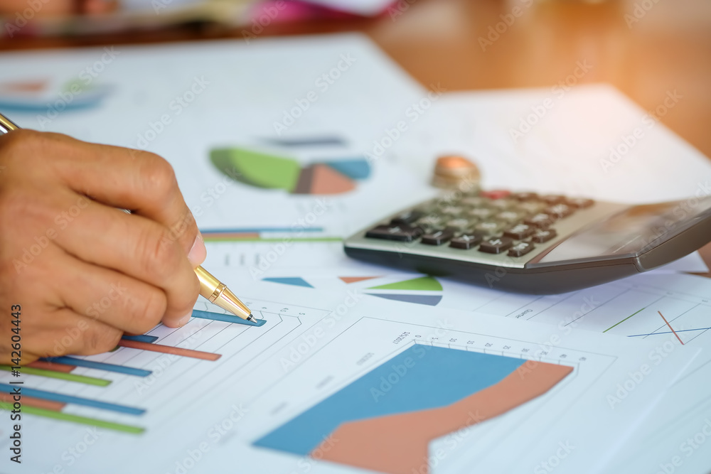 Men are using a calculator to analyze income data. Men are using a calculator to analyze income data.