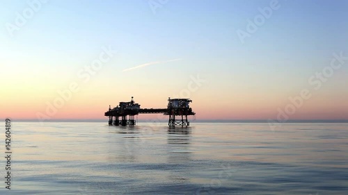 Silhouette of offshore oil platform at sunset