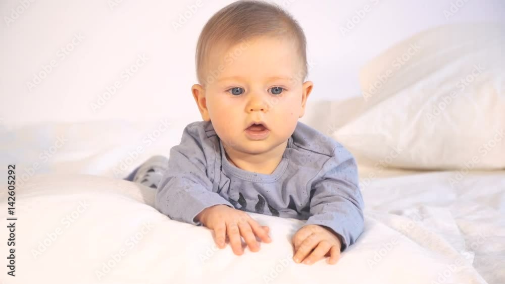 baby mit großen blauen augen und blonden haaren im bett baby mit großen blauen augen und blonden haaren im bett