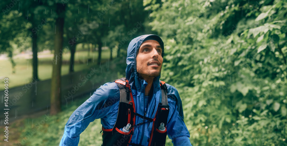 Φωτογραφία Fit male jogger day training in the rain for cross country forest trail race in a nature park