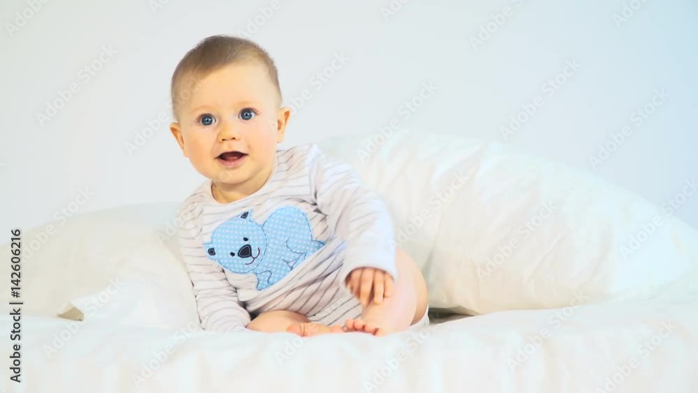baby mit großen blauen augen und blonden haaren im bett baby mit großen blauen augen und blonden haaren im bett