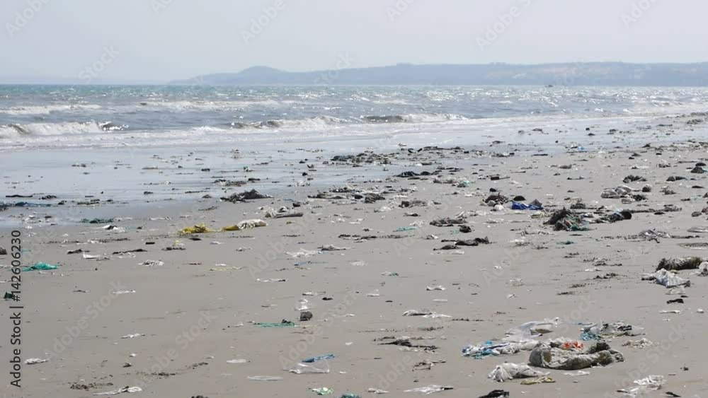 Pan shot of plastic garbage and trash on the beach on the sea background. Horrible ecological disaster on seashore Pan shot of plastic garbage and trash on the beach on the sea background. Horrible ecological disaster on seashore
