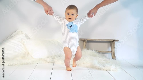 baby mit großen blauen augen und blonden haaren lernt gehen