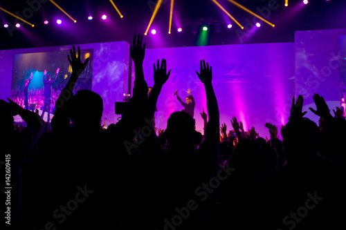 silhouettes of concert crowd in front of bright stage lights