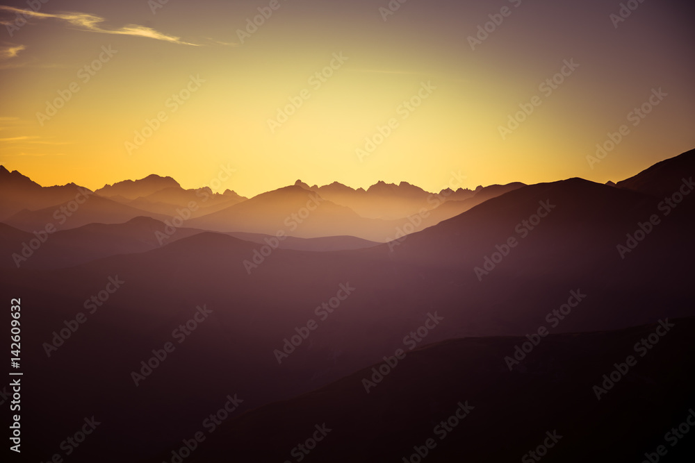 A beautiful, colorful, abstract mountain landscape in a mystic purple and orange tonality. Decorative, artistic look.