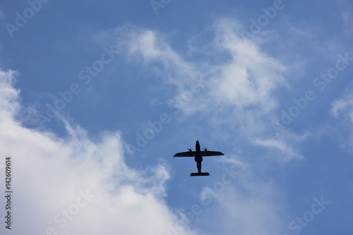 青空と飛行機。空想・飛行機を見つめる雲の動物の顔