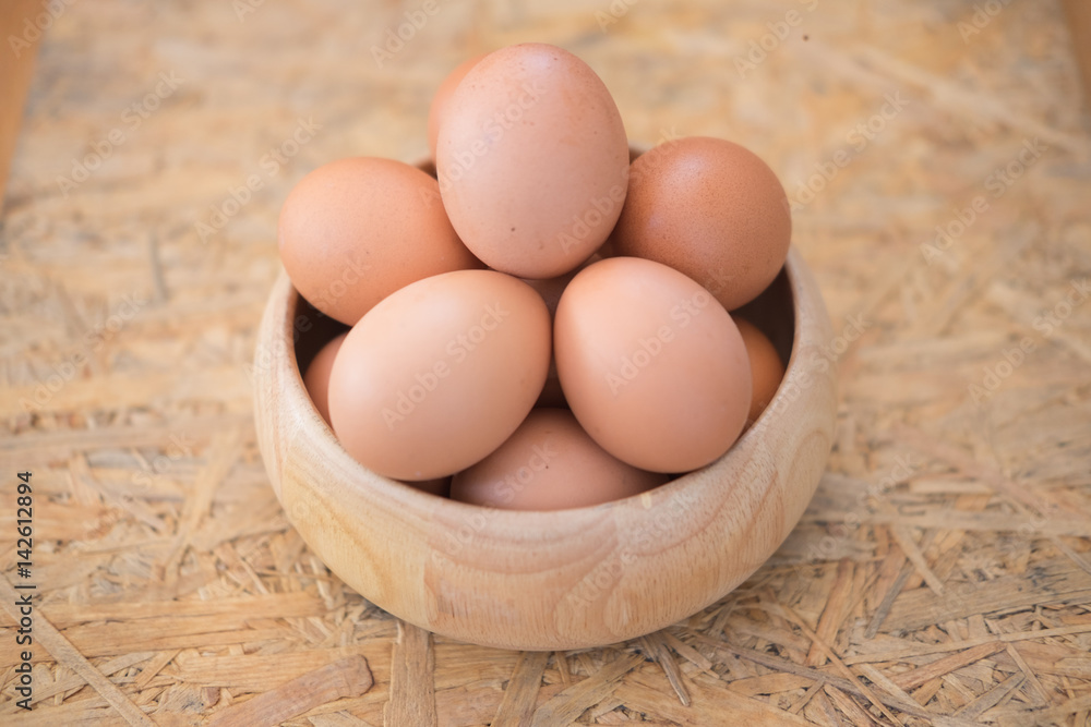 Egg in a wooden bowl on wooden table Egg in a wooden bowl on wooden table