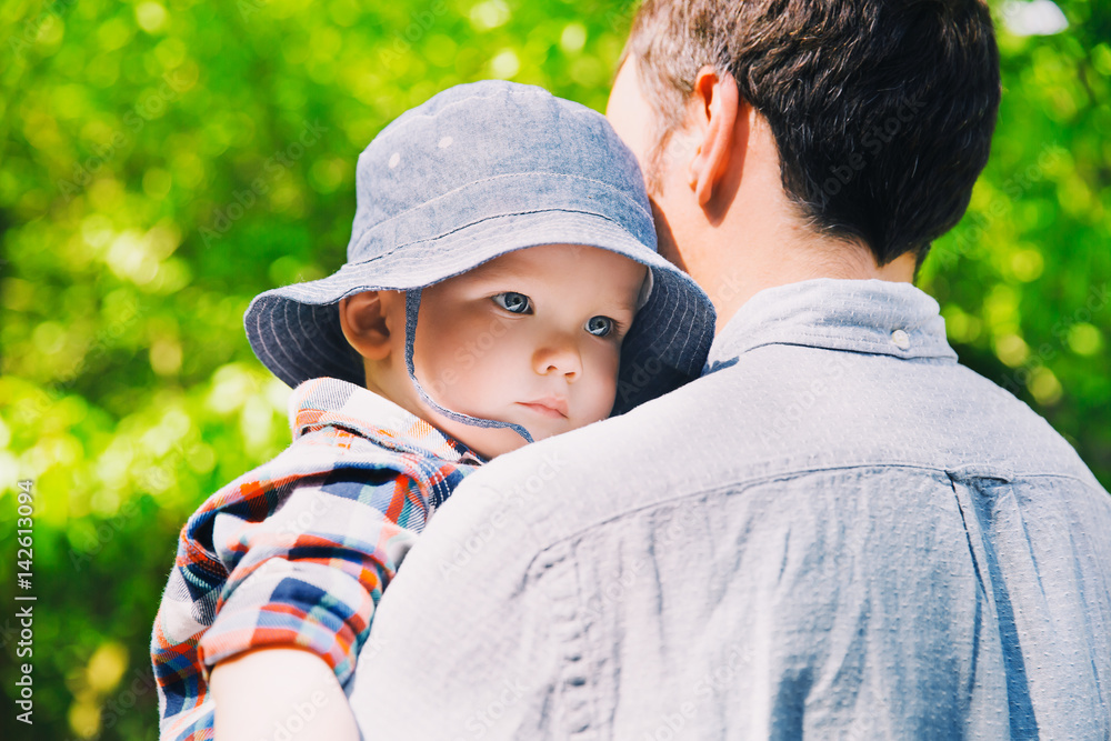 Father with son in the park at spring time on the background of nature Father with son in the park at spring time on the background of nature