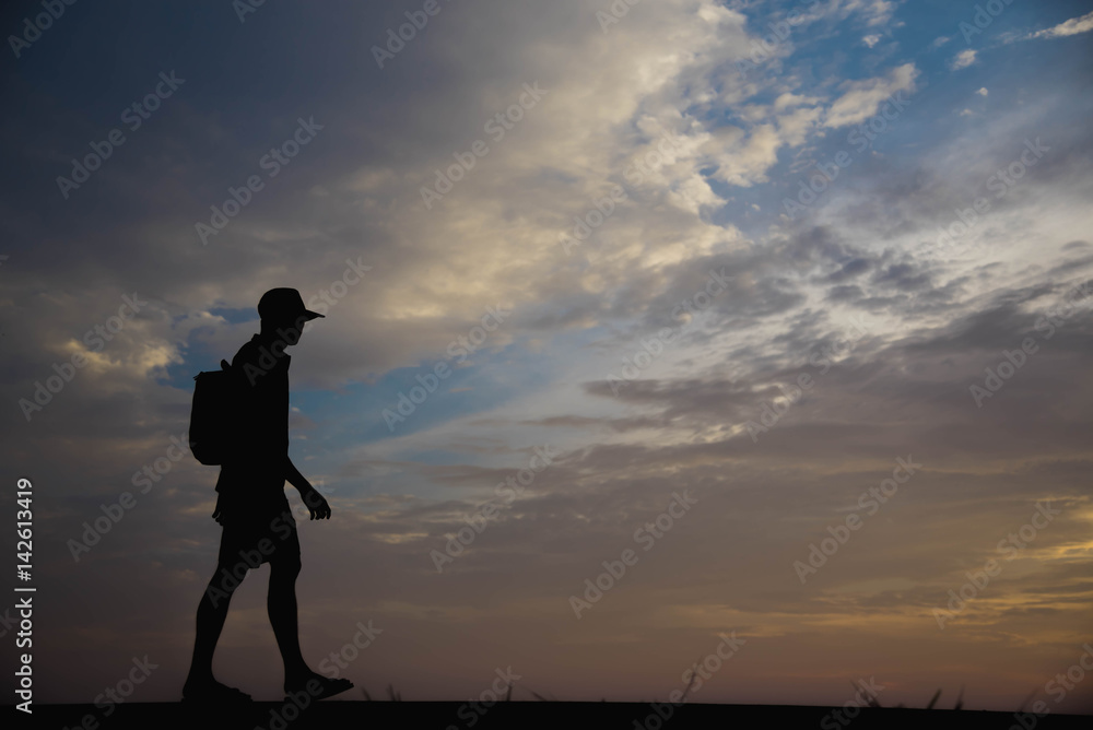 Silhouette of a man happy walking at sunset.