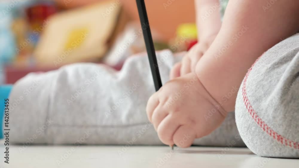 An attractive boy 2 years old draws in colorful pencils at home. It is black in the hand. An attractive boy 2 years old draws in colorful pencils at home. It is black in the hand.