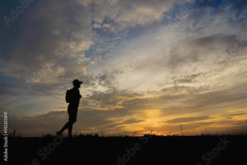 Silhouette of a man happy walking at sunset.