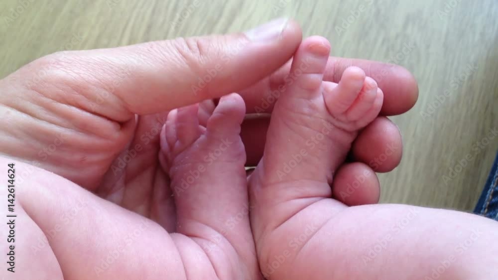 Father holding new born baby daughters feet in his hands Father holding new born baby daughters feet in his hands