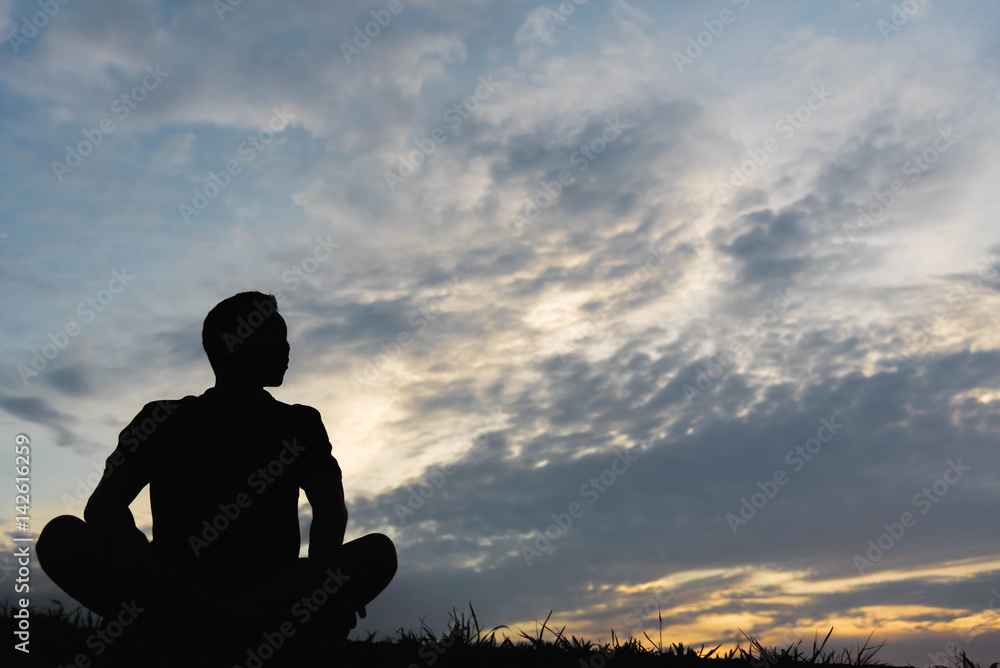 Silhouette of a man sitdown with so sad in the sunset.