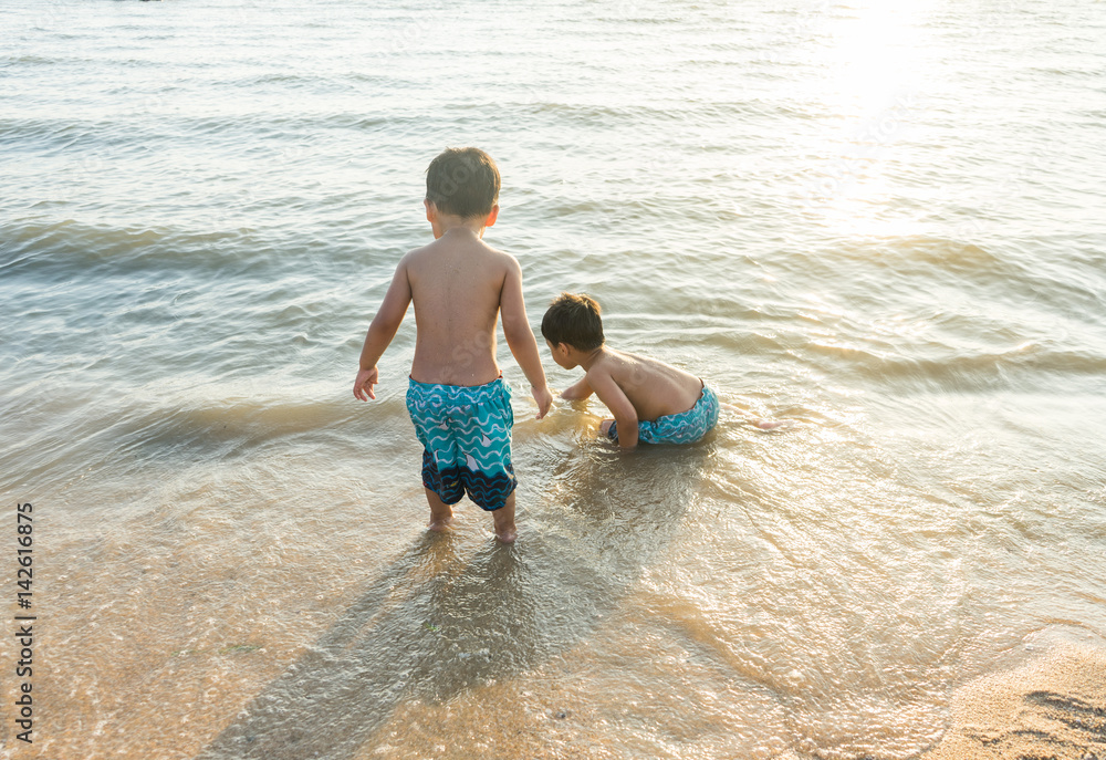happy asian boy playing in the water waves at sea ocean happy asian boy playing in the water waves at sea ocean