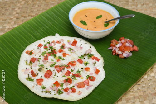 South Indian breakfast Oothappam / Dosa cooked using rice lentil and vegetables served with coconut chutney and sambhar . popular dish in Kerala and Tamil Nadu India. photo
