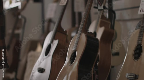 Young adult male looking at guitar in shop