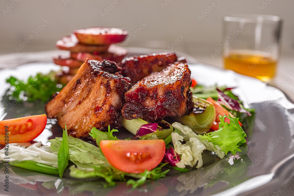 Hot Meat Dishes. Pork ribs grilled with salad and apples on a plate. Hot Meat Dishes. Pork ribs grilled with salad and apples on a plate.