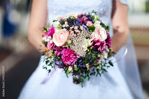 Beauty wedding bouquet in bride's hands, close - up