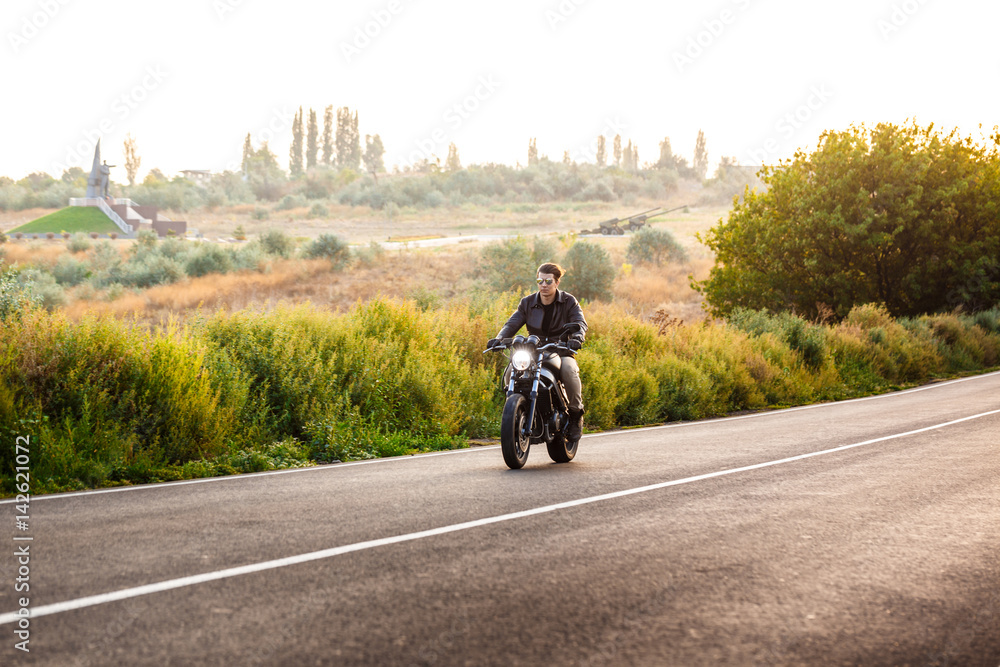 Young handsome man riding on motorbike at countryside road. Young handsome man riding on motorbike at countryside road.