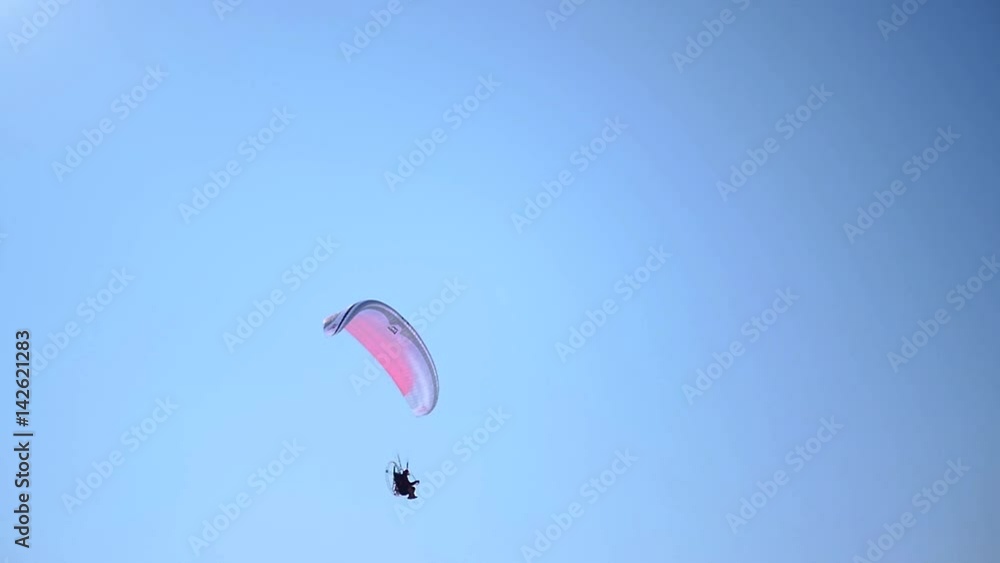 A red and blue paraglider hovers in the blue sky. HD 1080p. Slow motion. A red and blue paraglider hovers in the blue sky. HD 1080p. Slow motion.