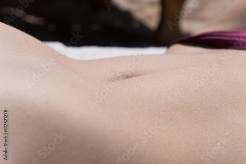 female sexy slim belly sunbathing