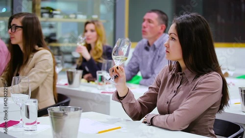 Beautiful woman tasting a white wine on degustation photo