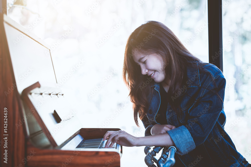 Asia beauty stylish woman playing a retro piano in free time Asia beauty stylish woman playing a retro piano in free time