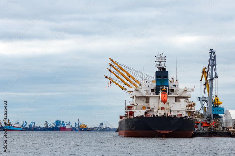 Black cargo ship loading in the port of Riga, Europe